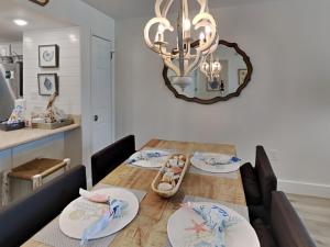 a dining room with a table with chairs and a mirror at Driftwood Towers #1F - Palm View in Gulf Shores