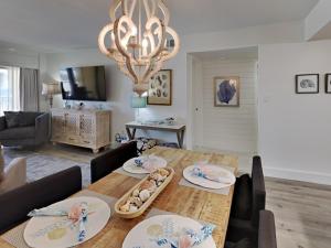 a living room with a dining table and a chandelier at Driftwood Towers #1F - Palm View in Gulf Shores