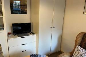 a bedroom with a dresser with a laptop on it at Ferienwohnung 1 Gemutlich & komfortabel im Erdgeschoss in Borkum