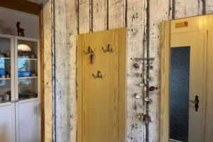 a yellow door with hooks on a wall at Ferienwohnung 1 Gemutlich & komfortabel im Erdgeschoss in Borkum