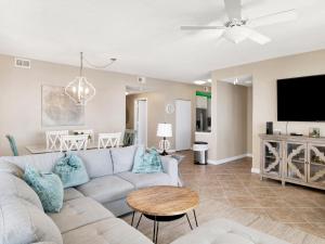 a living room with a couch and a tv at Beach Colony Towers #15C in Perdido Key +30 photos