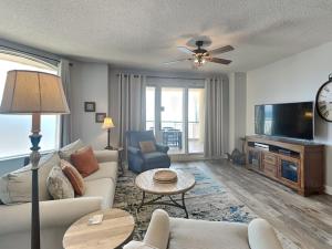 a living room with a couch and a tv at Beach Colony West #PH3B 18B in Perdido Key