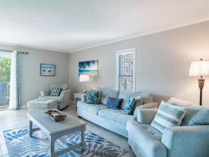 a living room with a couch and chairs and a table at Villas on the Gulf #E7 - Flip Flop Inn in Pensacola Beach