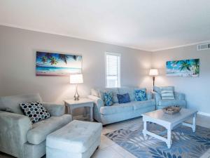 a living room with a couch and a table at Villas on the Gulf #E7 - Flip Flop Inn in Pensacola Beach