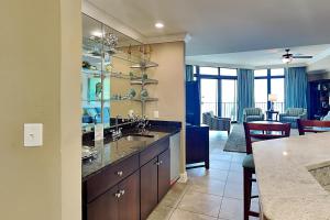 a kitchen with a sink and a living room at Phoenix West II #1407 in Orange Beach