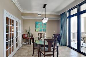 a dining room with a glass table and chairs at Phoenix West II #1407 in Orange Beach