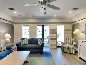 a living room with a couch and chairs and a ceiling fan at Aegean 327 in Destin