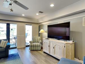 a living room with a large flat screen tv at Aegean 327 in Destin