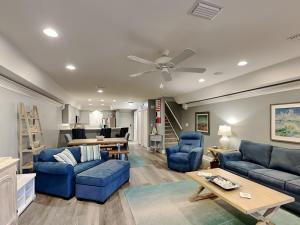 a living room with blue furniture and a ceiling fan at Aegean 327 in Destin