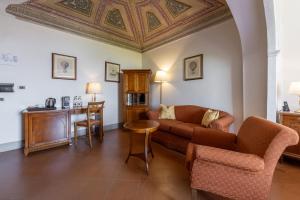 a living room with a couch and a table at Relais Cloister Pienza in Pienza