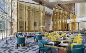a rendering of a restaurant with yellow tables and chairs at Hilton Astana in Astana