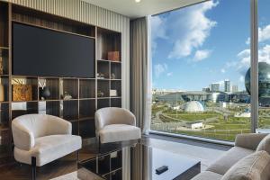 a living room with two chairs and a large window at Hilton Astana in Astana