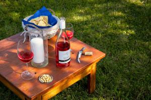 a wooden table with a bottle of wine and a basket of bread at Tenuta il Poggetto in Radda in Chianti