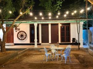 a table and chairs in front of a house at night at The Wild Lotus YALA in Tissamaharama