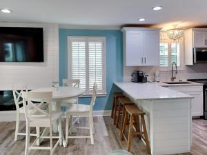 a kitchen with white cabinets and a table and chairs at Beachside Villas 911 in Seagrove Beach