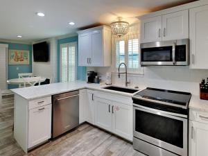 a kitchen with white cabinets and stainless steel appliances at Beachside Villas 911 in Seagrove Beach