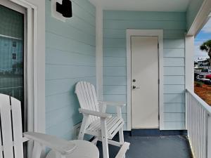 a pair of white chairs sitting on the porch of a house at Beachside Villas 911 in Seagrove Beach