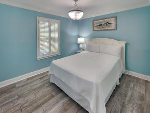 a bedroom with a white bed and blue walls at Beachside Villas 911 in Seagrove Beach +22 photos