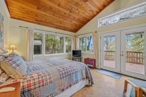 a bedroom with a bed and some windows at Above Sleepy Hollow - Rooftop Deck, Amazing Views, Hot Tub, Pet Friendly, Screen Porch, Wifi, EV Station, Games, Trails, Wood Stove, Charcoal Grill, Lake Access, King Bed in Hedgesville