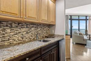 a kitchen with a sink and a living room at The Oasis at Orange Beach 1707 in Orange Beach +46 photos