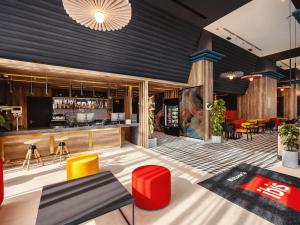 a lobby with a bar with red and yellow chairs at ibis Tbilisi City in Tbilisi City