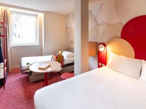 a hotel room with two beds and a table at Ibis Styles Strasbourg Centre République in Strasbourg +77 photos