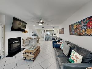 a living room with a couch and a fireplace at Tiki Tango Hideaway in Panama City Beach