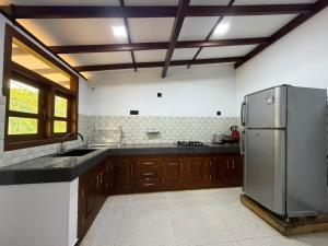 a large kitchen with a stainless steel refrigerator at Sunny's Hide Out in Talalla South
