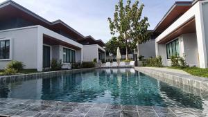 a swimming pool in front of a house at Green Mountain View villas Koh samui in Plai Laem
