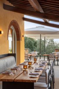 a long wooden table in a restaurant with chairs at Chapter Chianti, a Member of Design Hotels in Cavriglia
