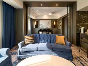 a blue couch in a living room with a table at Grand Mercure Imperial Palace Seoul Gangnam in Seoul