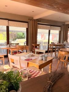 a dining room with tables and chairs and windows at Comme à la Ferme in Durbuy