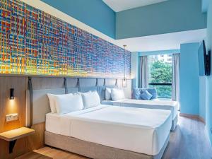 a bedroom with two beds and a wall with a mural at ibis Styles Kuala Lumpur Bukit Bintang in Kuala Lumpur +53 photos