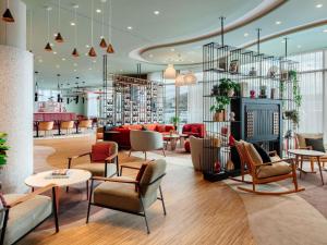 a lobby of a store with chairs and tables at Aparthotel Adagio Stuttgart NeckarPark in Stuttgart