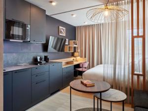 a kitchen with a bed and a table in a room at Aparthotel Adagio Stuttgart NeckarPark in Stuttgart