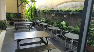 un patio con mesas, sillas y plantas en V Hotel Tebet, en Yakarta