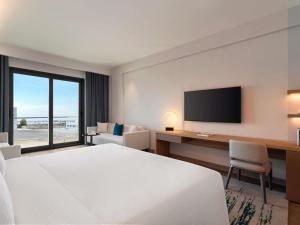 a hotel room with a bed and a desk and a television at Rixos Obhur Jeddah Resort & Villas - All-Inclusive in Jeddah