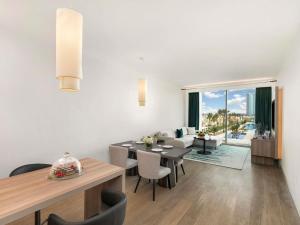 a dining room and living room with a table and chairs at Rixos Obhur Jeddah Resort & Villas - All-Inclusive in Jeddah