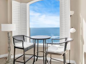 a table and chairs in a room with a view of the ocean at Beach Colony Towers #15C in Perdido Key