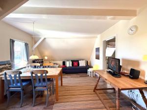 a dining room and living room with a table and chairs at Deichhof Whg 27 in Dunsum