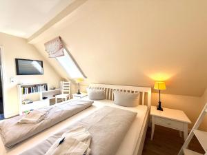 a bedroom with two beds and a book shelf at Deichhof Whg 27 in Dunsum