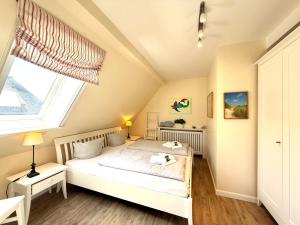 a bedroom with a bed and a window at Deichhof Whg 27 in Dunsum +5 photos