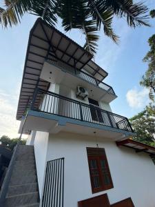 a white building with a balcony and stairs at Sunny's Hide Out in Talalla South