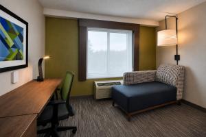 a room with a chair and a desk and a window at Holiday Inn Express & Suites Halifax Airport by IHG in Enfield +47 photos