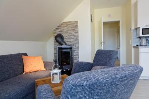a living room with two blue couches and a fireplace at Vineta Ferienpark Usedom in Koserow