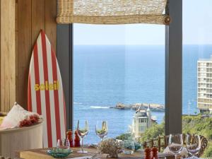 a table with a view of the ocean from a window at Le Talaia Hôtel & Spa Biarritz - MGallery Collection in Biarritz