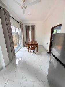 a living room with a table and a television at Blue Wave Holiday Villa in Weligama