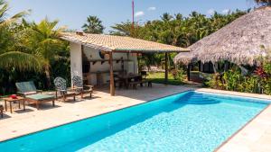 a villa with a swimming pool and a hut at Refugios Parajuru - Villa Alegre in Parajuru