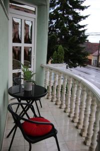 a table and a chair on a balcony at Erika Panzió in Ditrău +11 photos