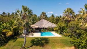 a resort with a swimming pool and palm trees at Refugios Parajuru - Villa Alegre in Parajuru